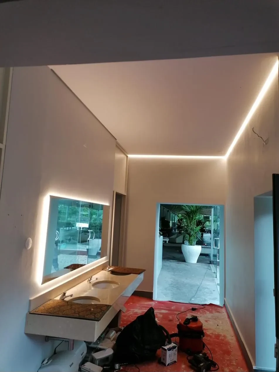 Casa de banho com espelho retroiluminado e LED em sanca no teto, em fase final de obra