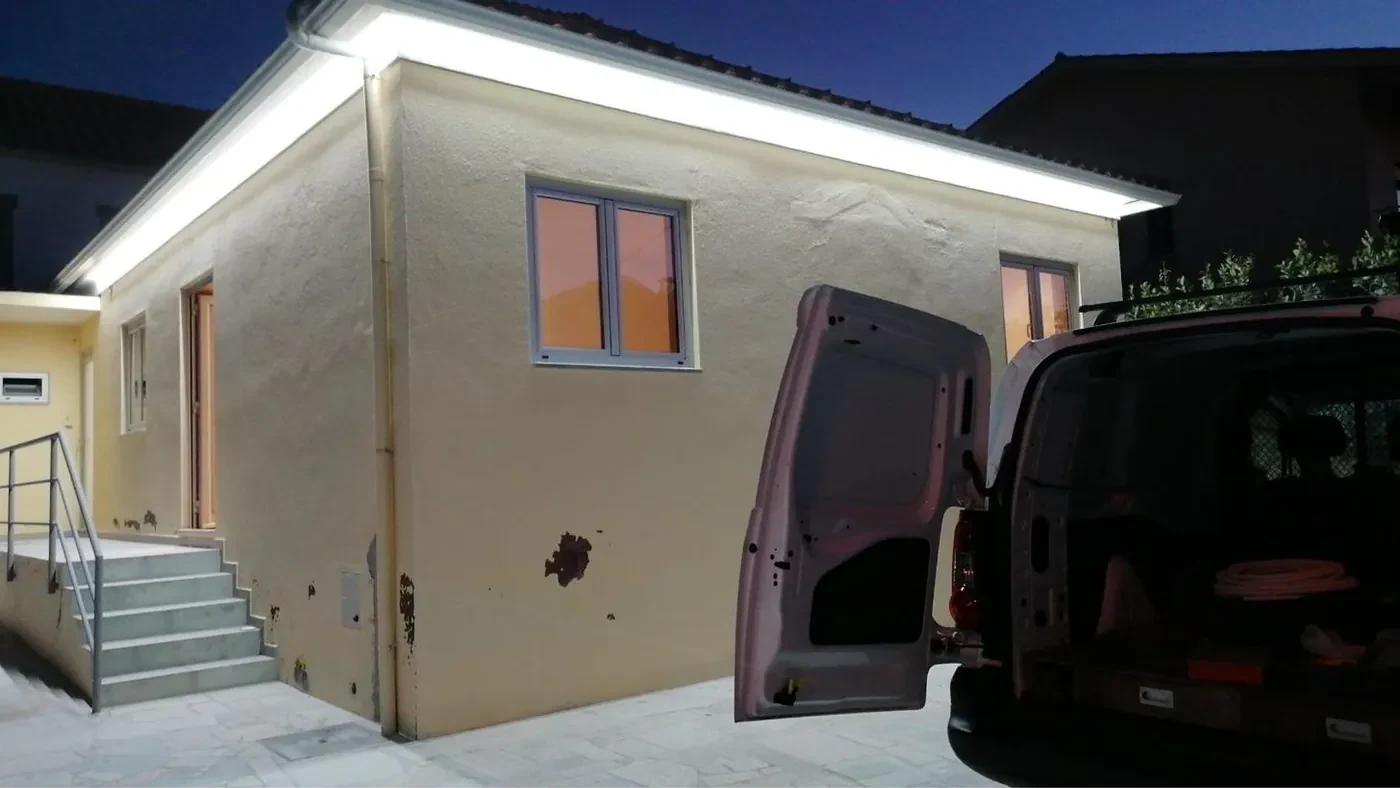 Fachada de moradia ao anoitecer com iluminação LED contínua sob o beirado