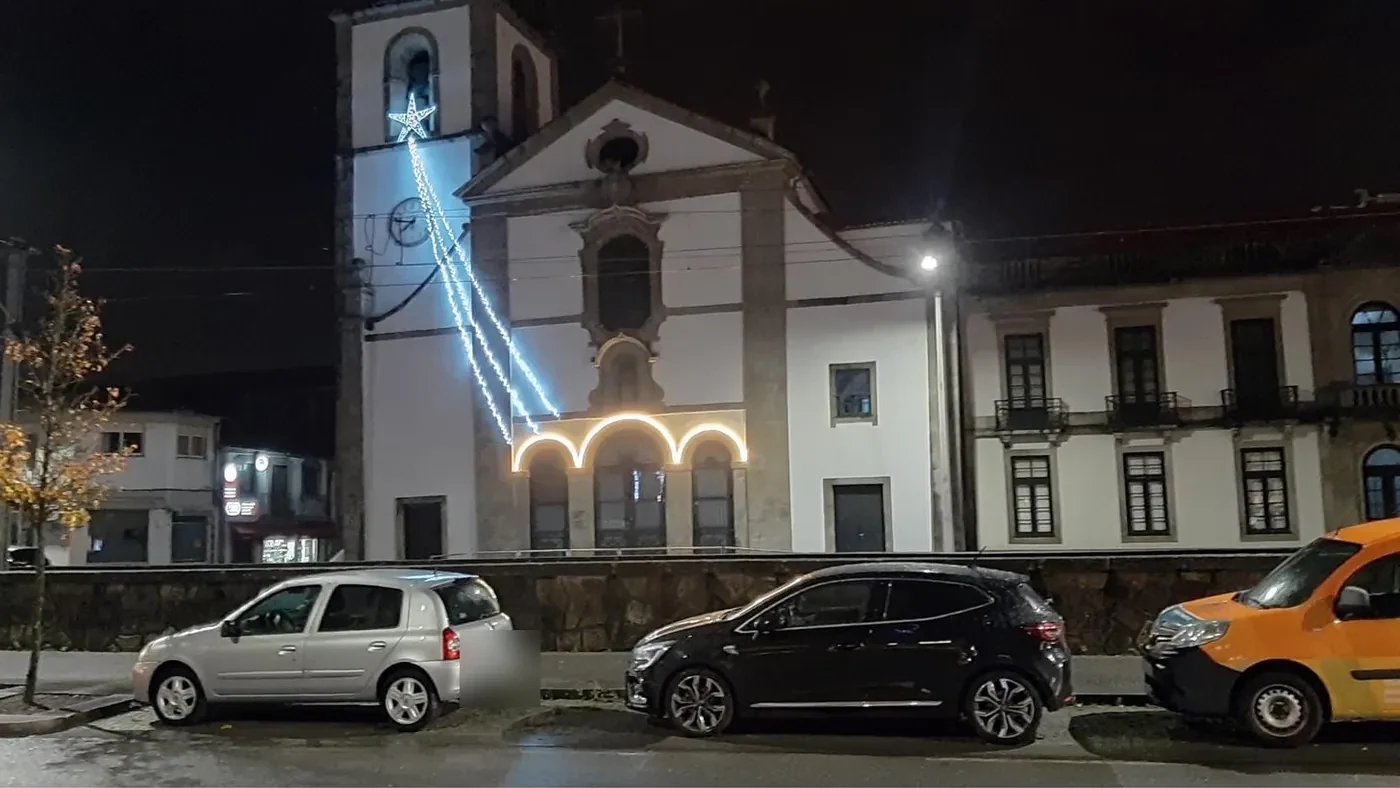 Igreja à noite com estrela cadente e arcos luminosos na fachada
