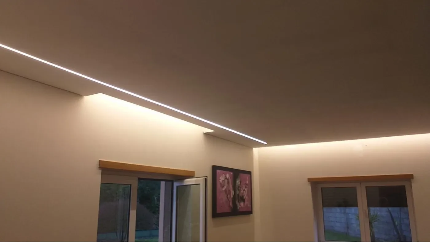 Sala com perfil LED linear no teto e iluminação indireta em sanca